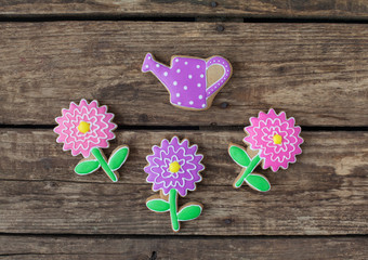 Homemade gingerbread cookies in the shape of flowers on wooden table