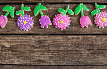 Homemade gingerbread cookies in the shape of flowers on wooden table