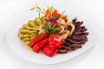 Grilled Vegetables Appetizer, eggplant, zucchini, mushrooms, tomatoes and greens. Isolated dish on a white background