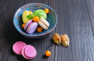 Multicolored macaroon cookies in a blue ceramic bowl