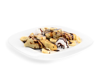 Pancakes with banana slices, ice cream and chocolate isolated on white