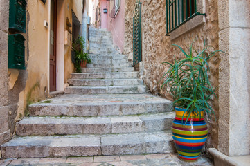 Fototapeta na wymiar A characteristic narrow alley of Taormina, Eastsicily, with some typical colored ceramic vases