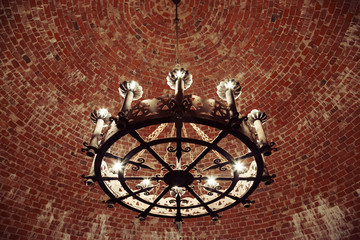 Retro chandelier hanging in the brick ceiling