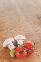 Champignons, olives and cherry tomato on wooden table