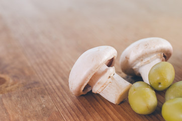 Mushrooms and olives on wooden table