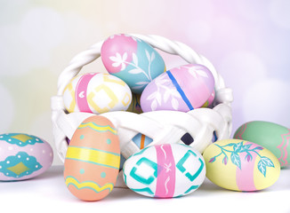 Fototapeta na wymiar Assortment of Painted Easter Eggs and Basket on Colorful Background