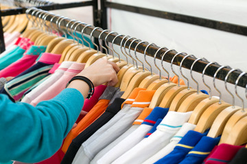 Young woman looking new shirt shopping in store.