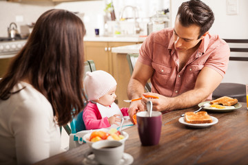 Obraz na płótnie Canvas Parents eating breakfast with baby girl