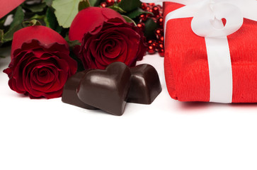 Red present box with white ribbon, red roses and candies