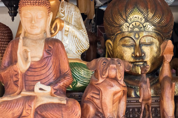 Wooden figures of Buddha, dogs, horses, and one of the metal
