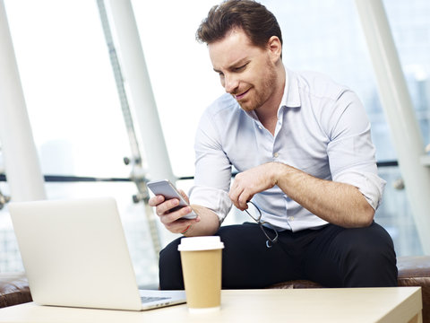 business person reading text messages on cellphone