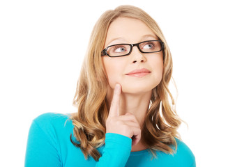 Thoughtful teenage woman looking up