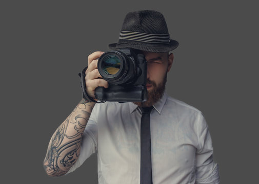Photographer in white shirt and casual hat.