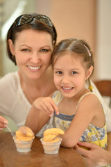 Obraz na płótnie Canvas girl and mother eating ice creams