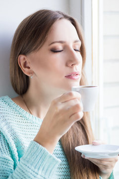 Young beautiful woman enjoying cup of espresso