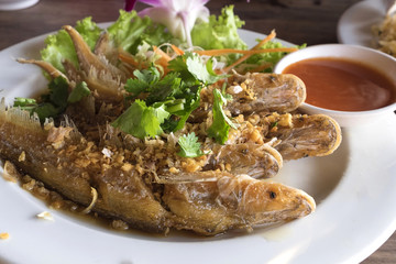 fired fish with garlic and fresh vegetable on dish