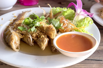 fired fish with garlic and fresh vegetable on dish