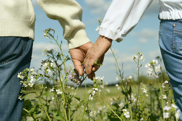 Couple holding hands with flowers