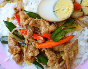 stir fried pork with sweet long chili and topping half brown boiled egg on rice
