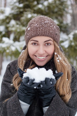 girl outdoor portrait. Winter woman blowing snow in a park, closeup