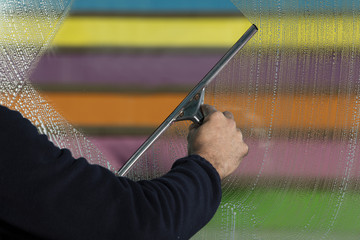 window cleaner using a squeegee to wash a window