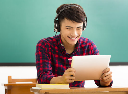 Happy Student Reading Tablet In Classroom