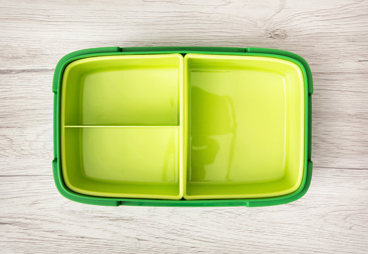 Green plastic food box on the wooden background