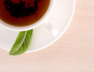 Teacup and  a leaf  of mint