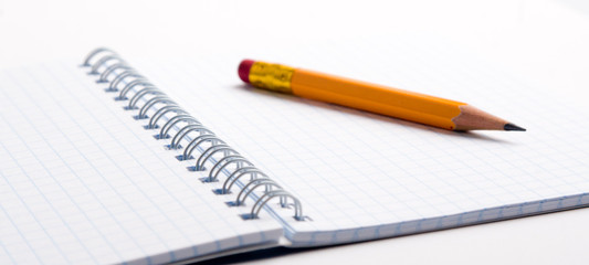 Pencil on the notepad isolated closeup