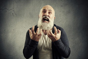yelling senior man over grey background