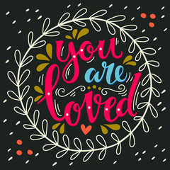 You are loved. Hand lettering in wreath with decoration elements