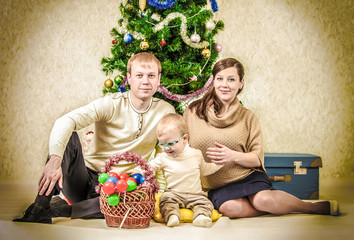 Vintage family portrait of young couple with little boy near Chr