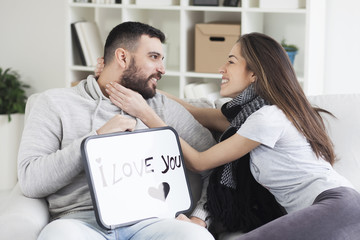Young couple showing love message written on white board. I love you message. Valentines couple,shallow depth of filed