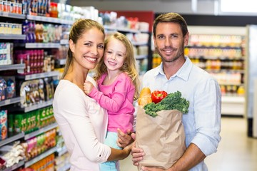 Smiling family with grocery bag at the supermarket