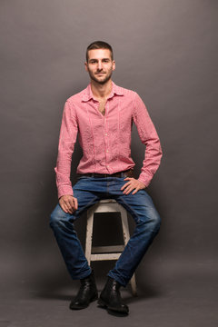 Handsome Man Sitting On A Chair In Studio