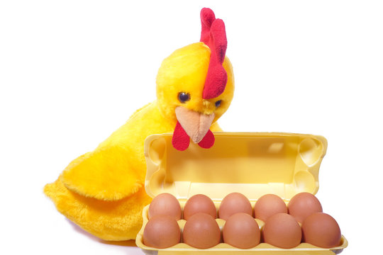 Ten chicken eggs in yellow box with toy rooster (white backgroun