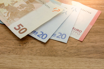 different euro banknotes on wooden table