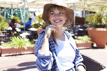 Blue eyed young woman in hat, looking away