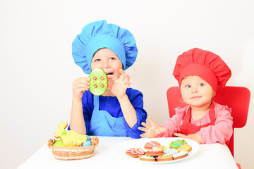 cute little boy and girl playing with easter cookies