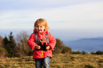 little tourist with binoculars travel in mountains