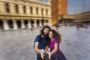 Cheerful tourists making selfie photo in Venice