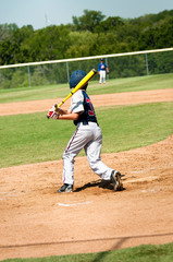 Teen baseball player swinging bat
