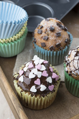 Photo of tasty cupcakes with chocolate over wooden table