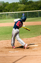Teen baseball player swinging bat