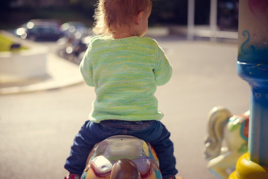 Happy Baby Riding On Carousel