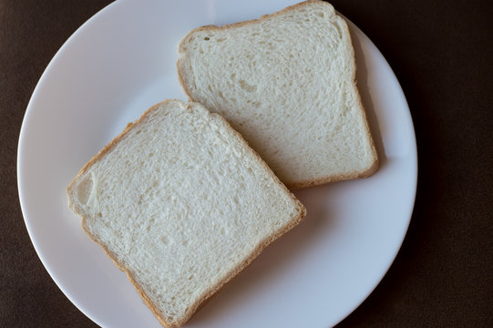 2 slices of white bread on a white plate