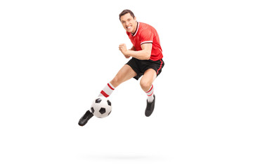 Young football player kicking a ball