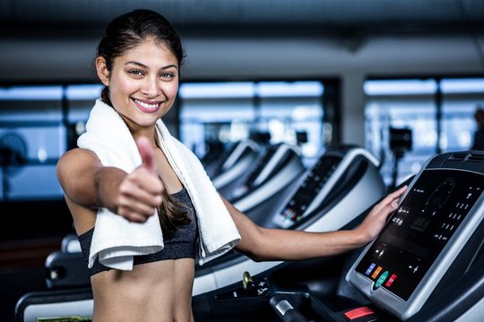 Smiling fit woman showing thumbs up