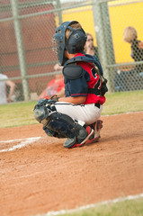 Young baseball catcher behind home base.