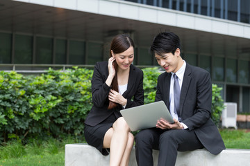 Two business people use of notebook computer outdoor